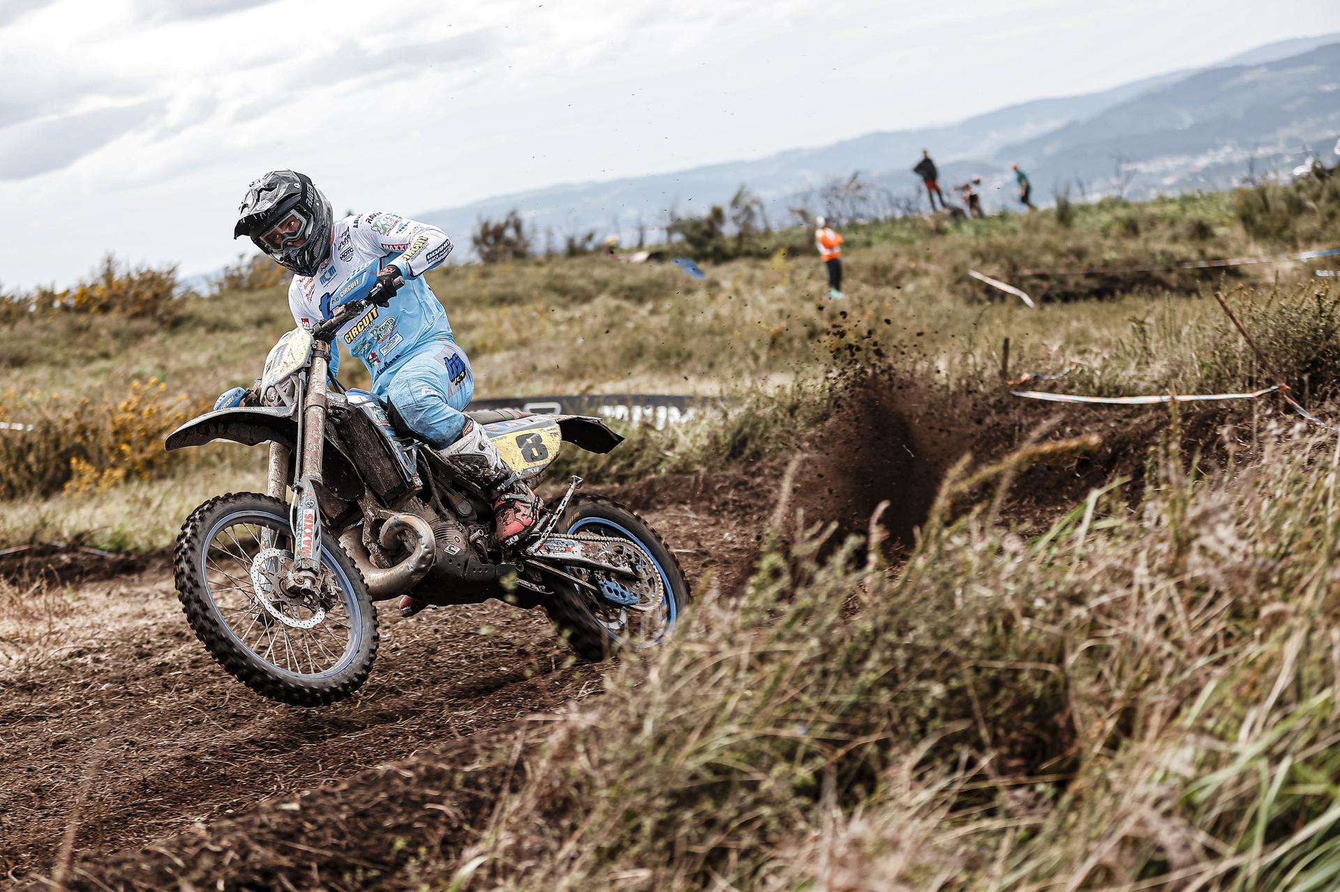 Piloto TM trazando una curva de tierra en enduro