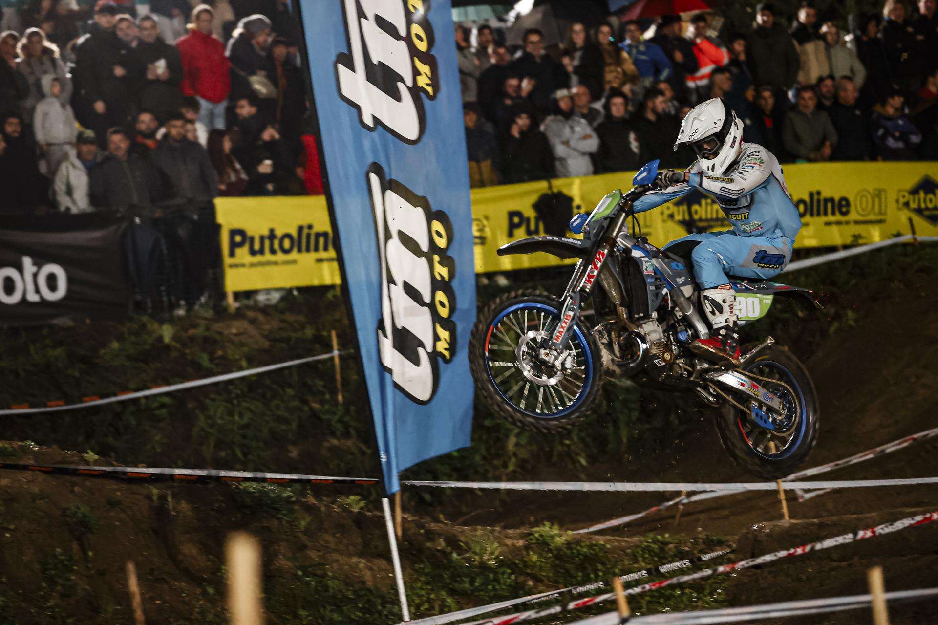 Piloto TM superando un salto en una prueba de enduro nocturna